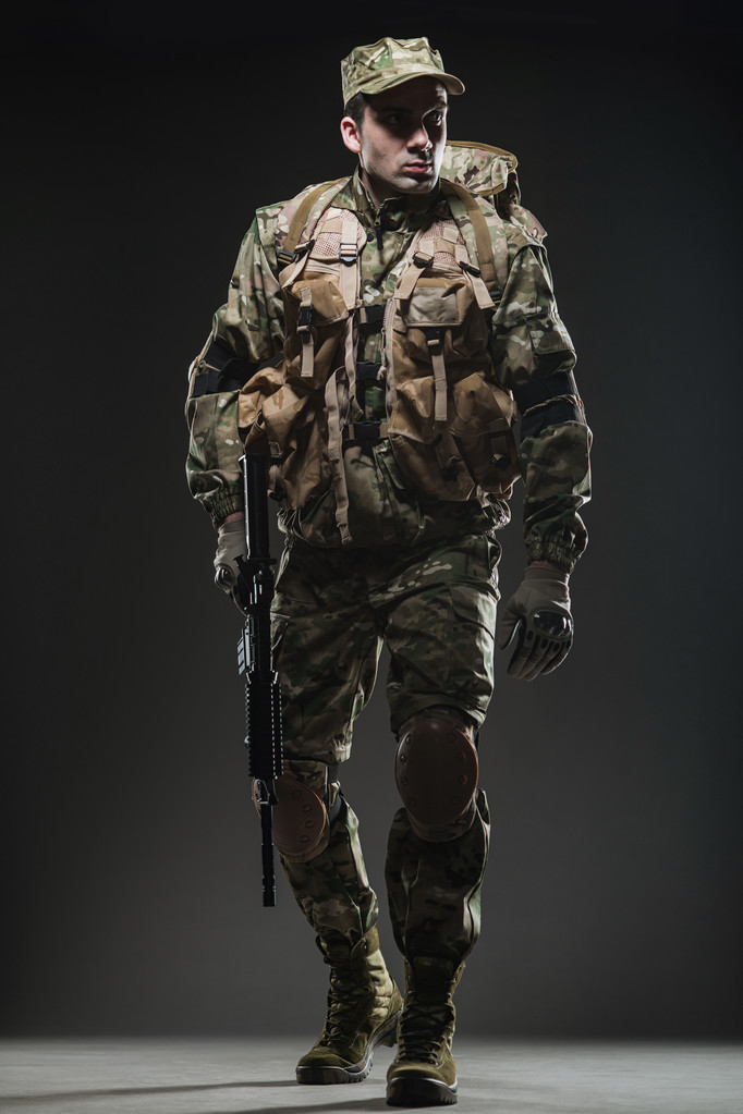 soldato uomo tenere mitragliatrice su uno sfondo scuro
 - Foto, immagini