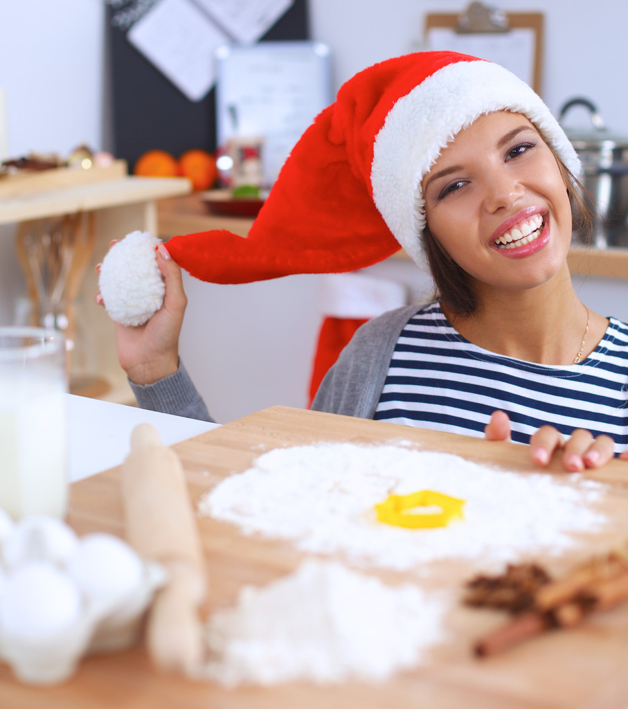 Glückliche junge Frau lächelt glücklich Spaß mit Weihnachtsvorbereitungen mit Weihnachtsmütze - Foto, Bild