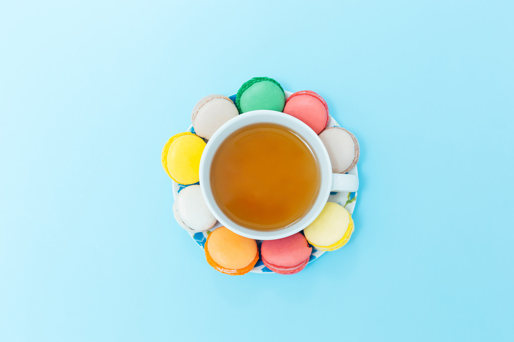 紅茶のカップとカラフルなマカロン - 写真・画像