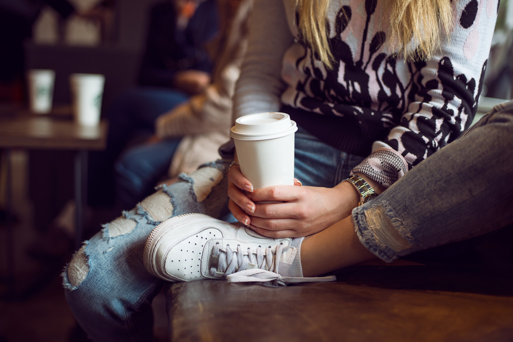 Nő kezet tartó kávé papírpohár kávézóban ülve - Fotó, kép