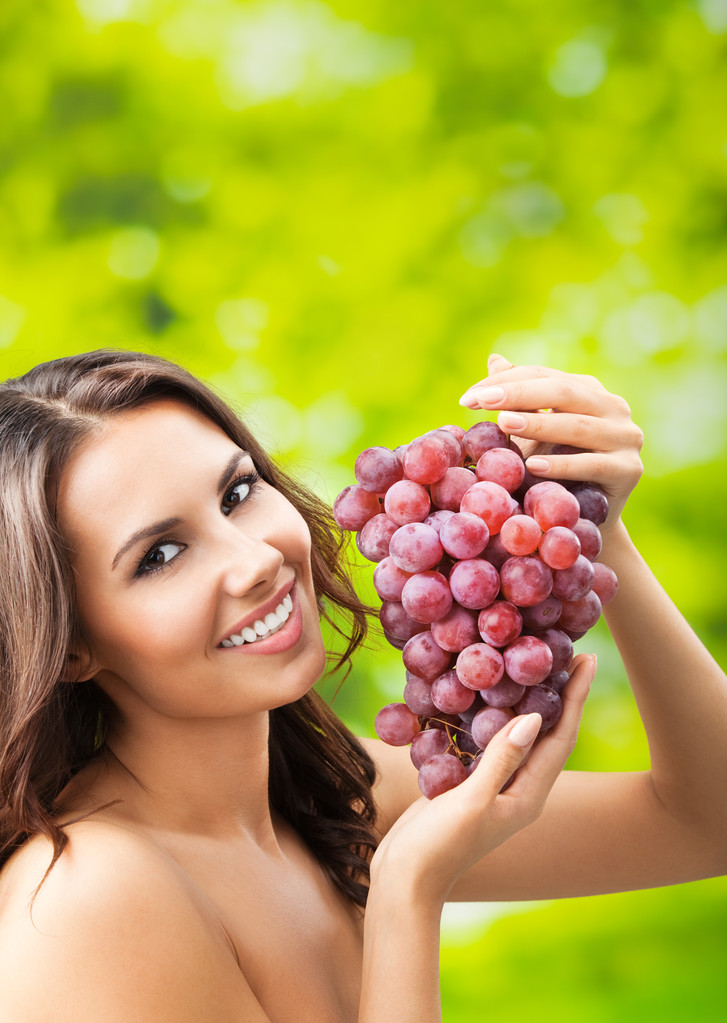 Young happy smiling woman with grapes, outdoors - Photo, Image
