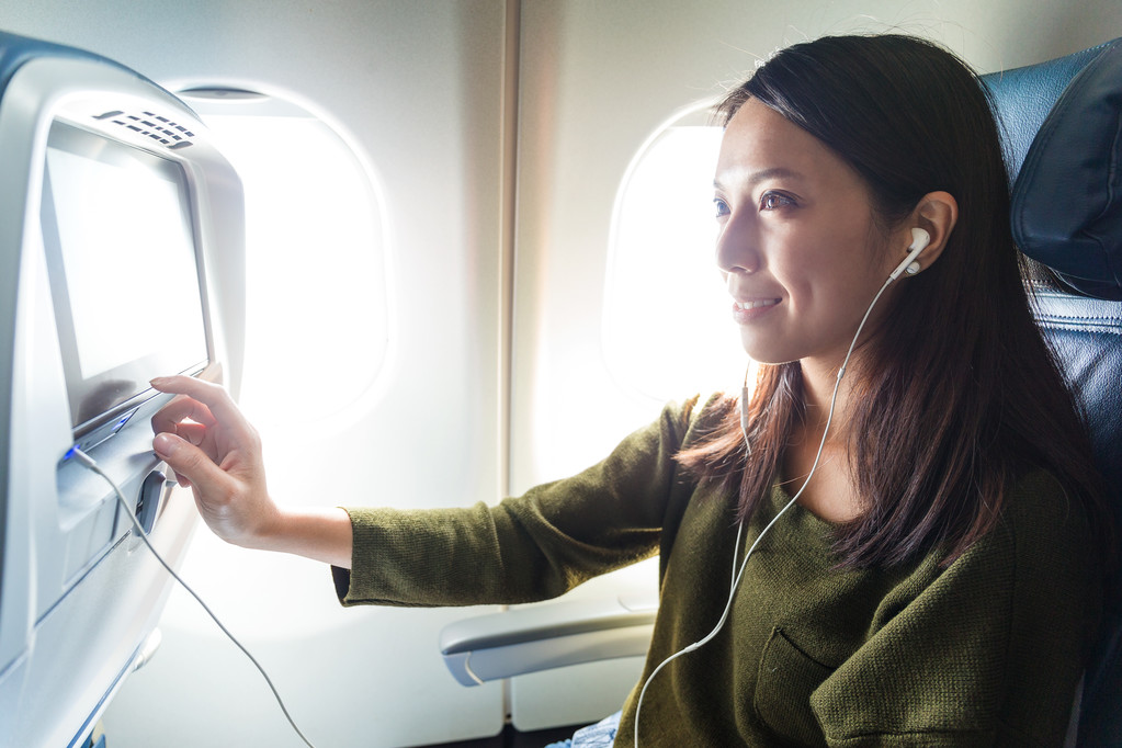 Женщина смотрит кино в самолете
 - Фото, изображение
