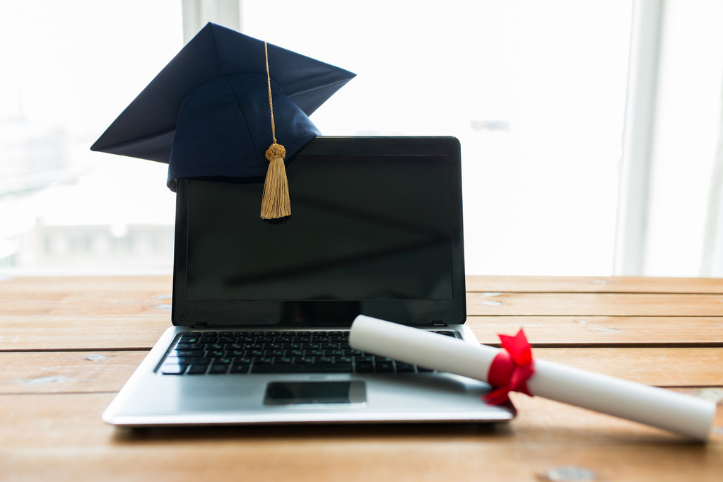 close up of laptop with mortarboard and diploma - Photo, Image