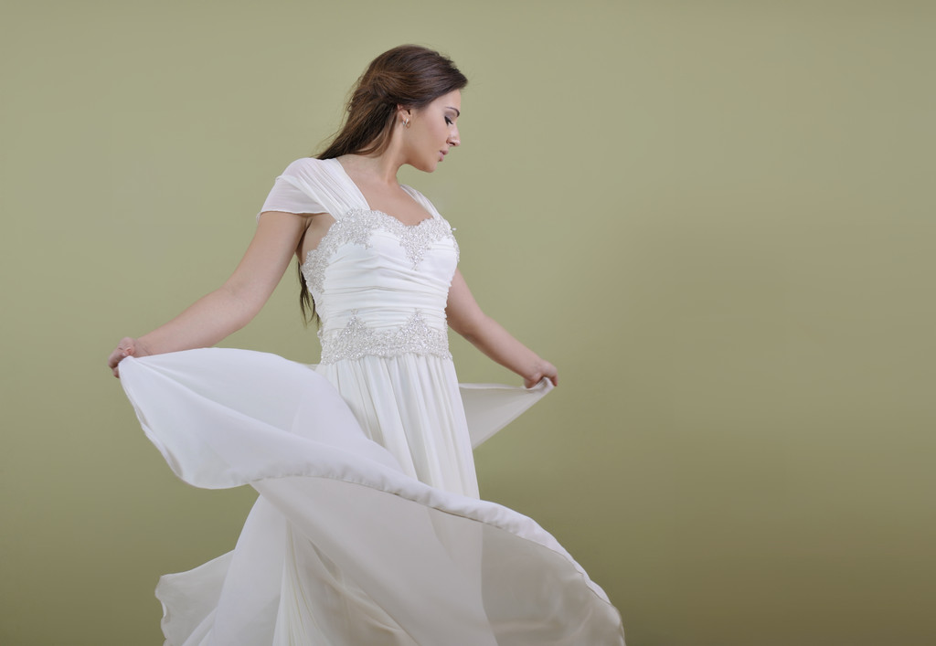 Elegáns nő divatos ruhában pózol a stúdió - Fotó, kép