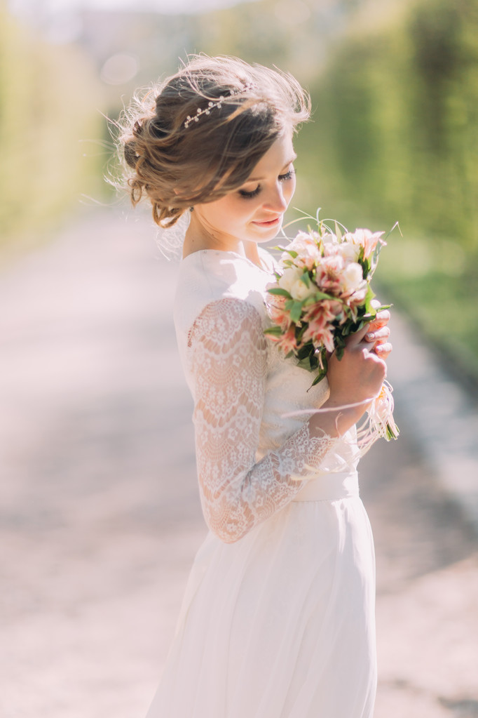 Belle mariée blonde avec bouquet de fleurs de printemps en plein air
 - Photo, image