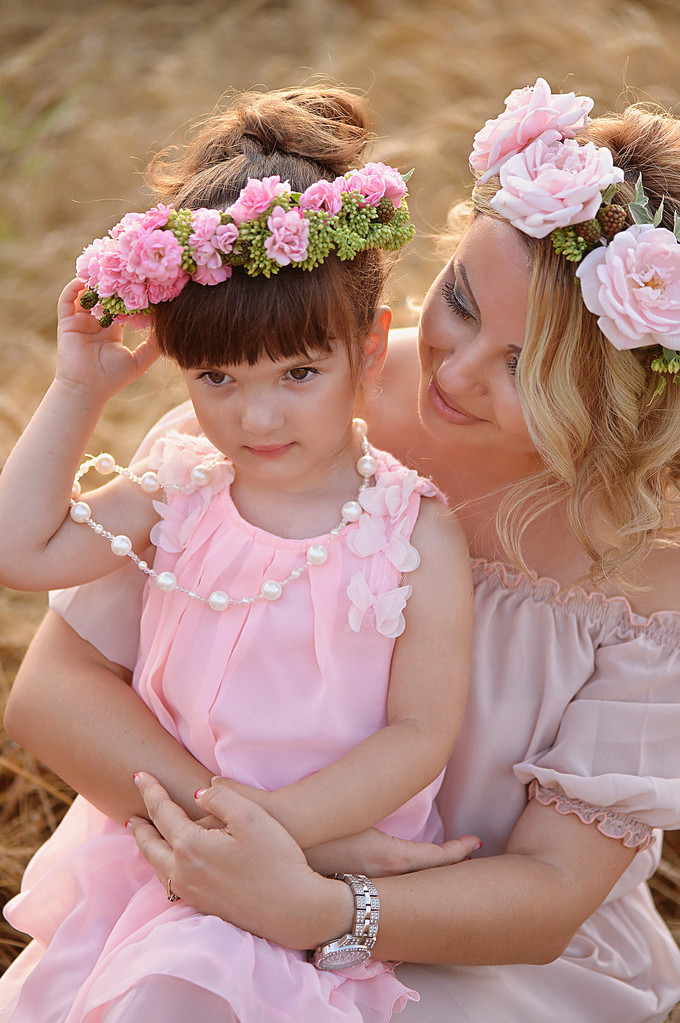 Mother and daughter hugging on her head a garland of roses, soft image - Photo, Image