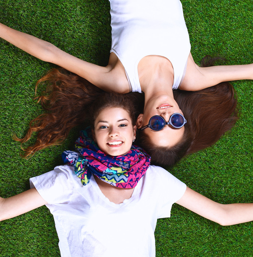 Dos chicas guapas tumbadas en la hierba verde fresca - Foto, Imagen