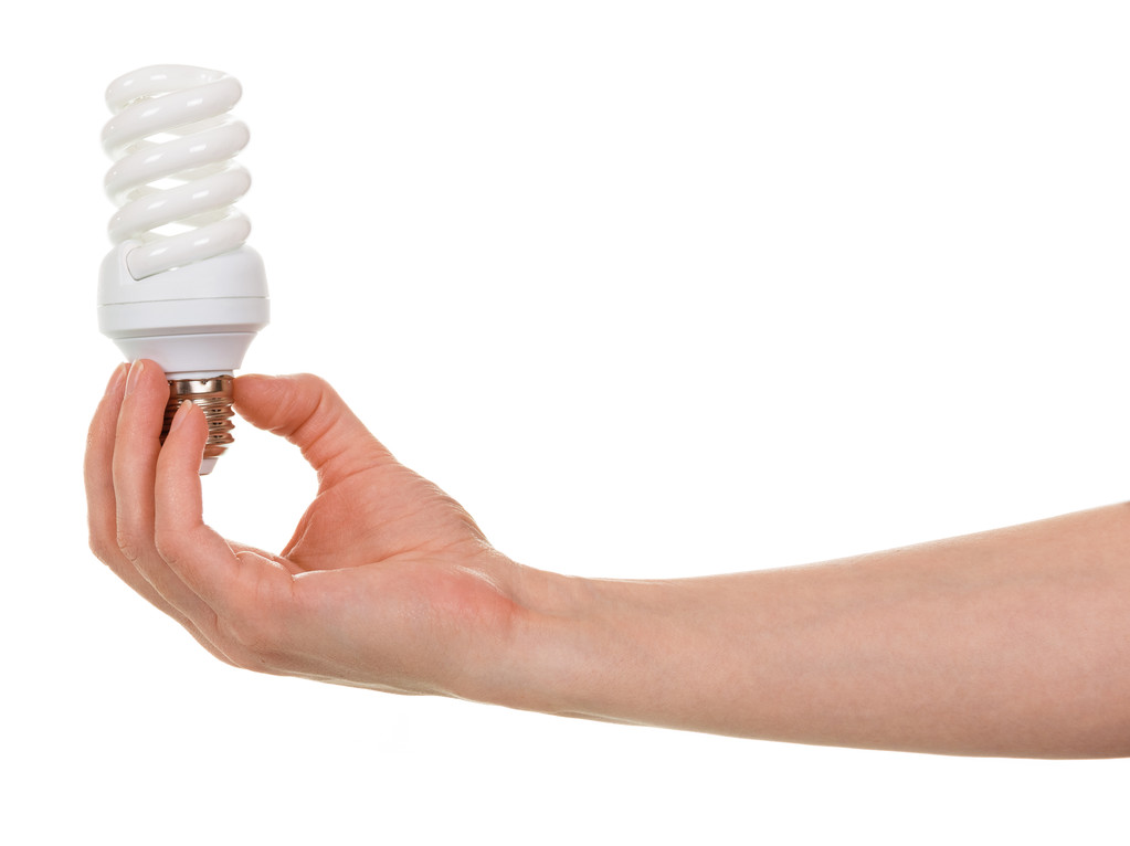 Lámpara fluorescente compacta en forma de espiral de mano aislada en blanco
. - Foto, Imagen