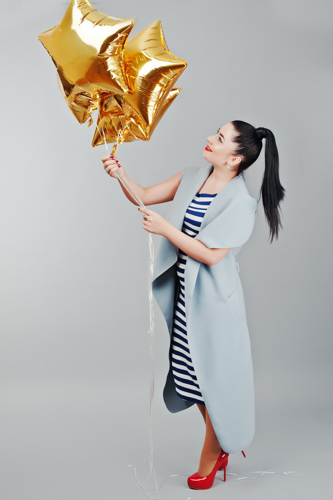 Jovem mulher sorriu com balões de ouro em mãos fundo cinza i
 - Foto, Imagem
