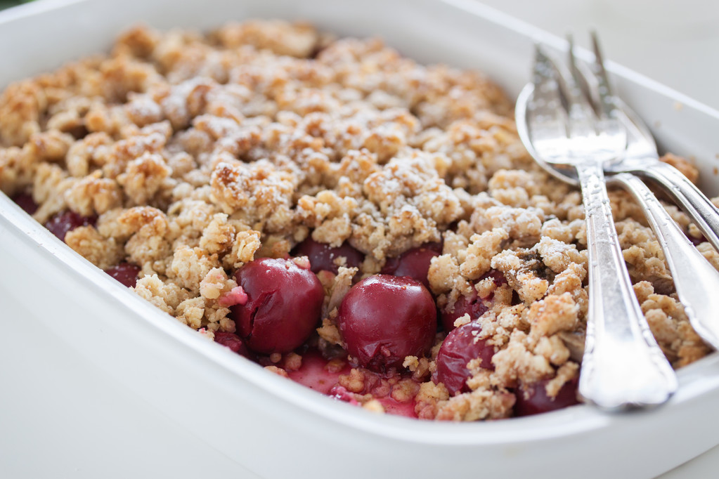 Zelfgemaakte verse zoete Cherry crumble Pie met volkoren meel op een witte keuken tafel achtergrond klaar om te eten, close-up - Foto, afbeelding