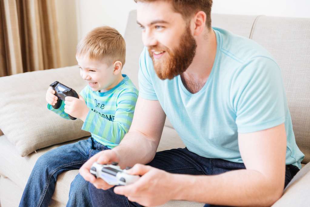 Kleine zoon en vader spelen van computerspelletjes thuis samen  - Foto, afbeelding