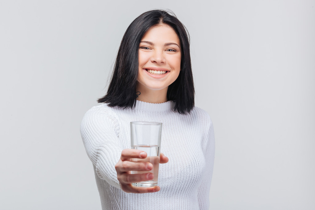 Όμορφη νέα γυναίκα που κρατά ποτήρι νερό - Φωτογραφία, εικόνα