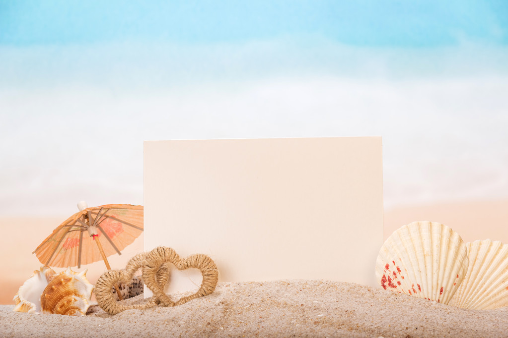 Tarjeta en blanco con conchas de mar, corazones en arena en la playa
. - Foto, imagen