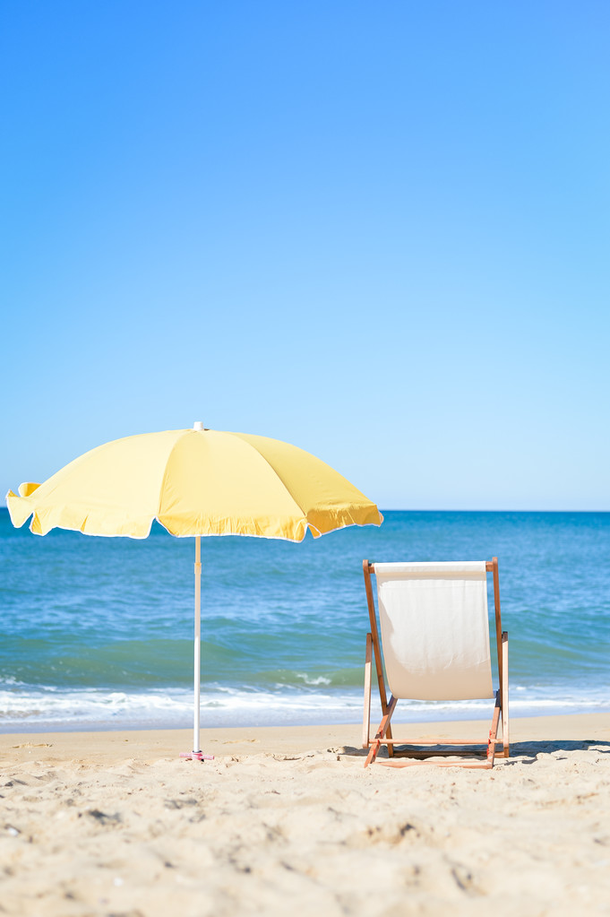 Rückenansicht Liegestuhl, Sonnenliege unter Sonnenschirm am Sandstrand. - Foto, Bild