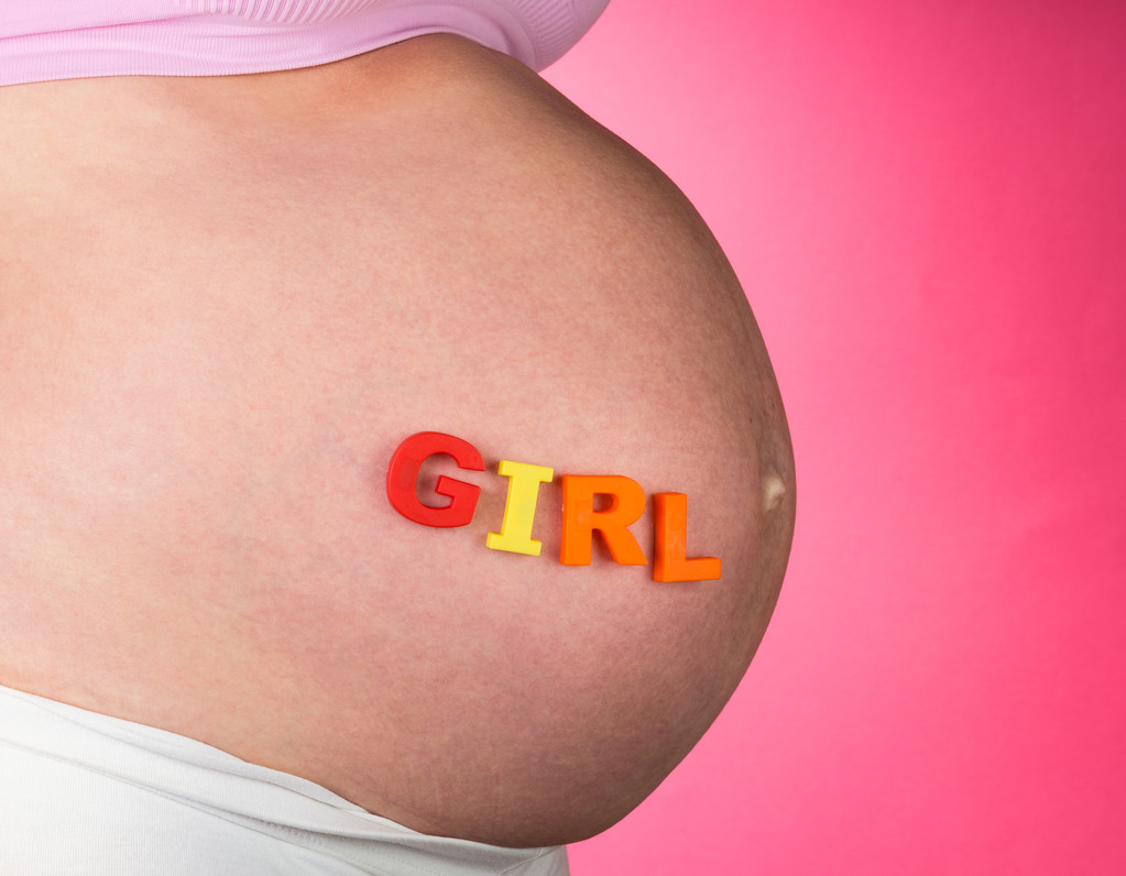 Göbek olan pembe bir arka plan üzerinde kelime kız hamile kadın. - Fotoğraf, Görsel