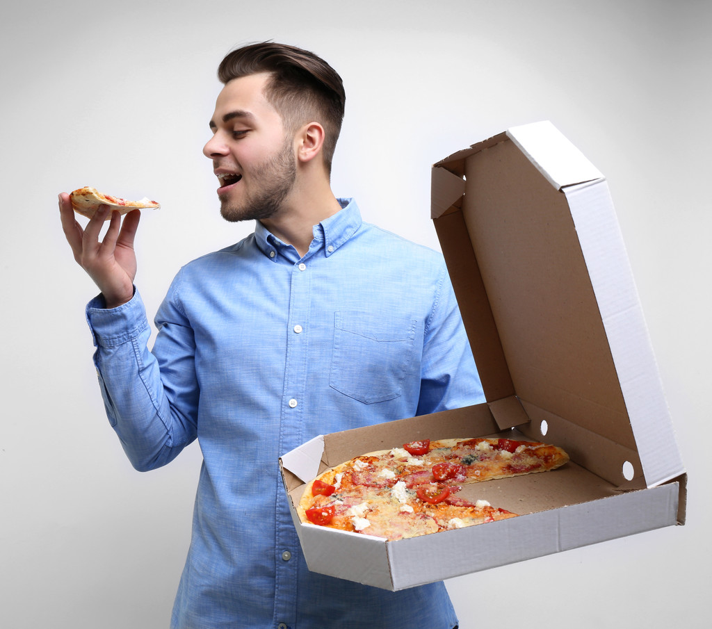Nuori komea mies pizzan kanssa   - Valokuva, kuva
