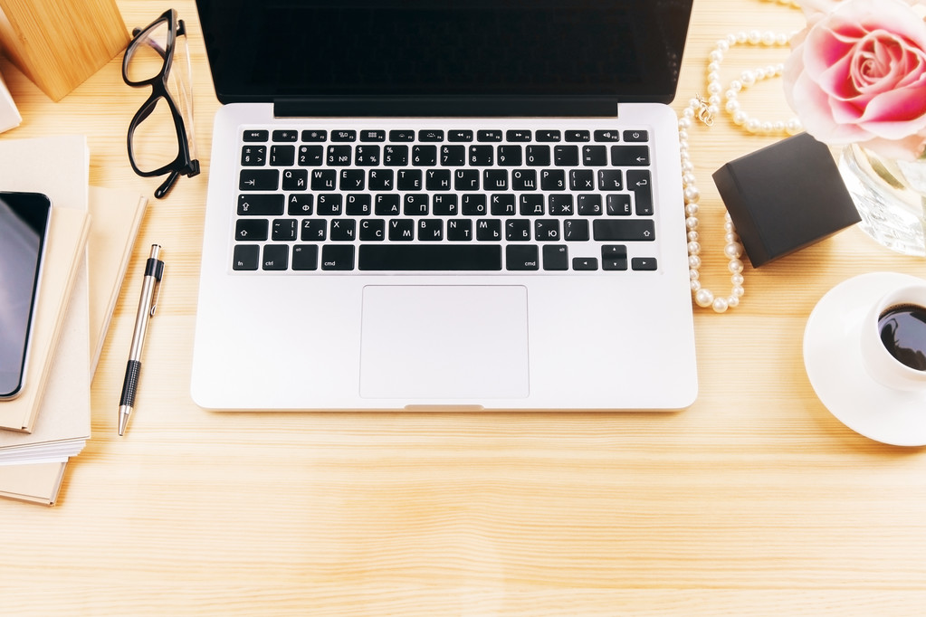 Vista dall'alto del desktop del designer femminile con fiore, laptop, tazza di caffè, occhiali e strumenti per ufficio
 - Foto, immagini
