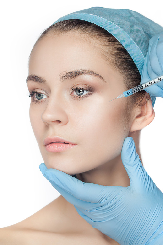 Ελκυστική γυναίκα στην πλαστική χειρουργική με σύριγγα στο πρόσωπό της - Φωτογραφία, εικόνα