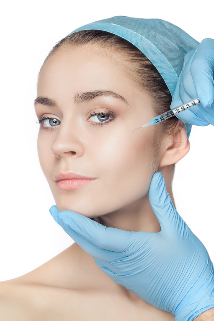 Ελκυστική γυναίκα στην πλαστική χειρουργική με σύριγγα στο πρόσωπό της - Φωτογραφία, εικόνα