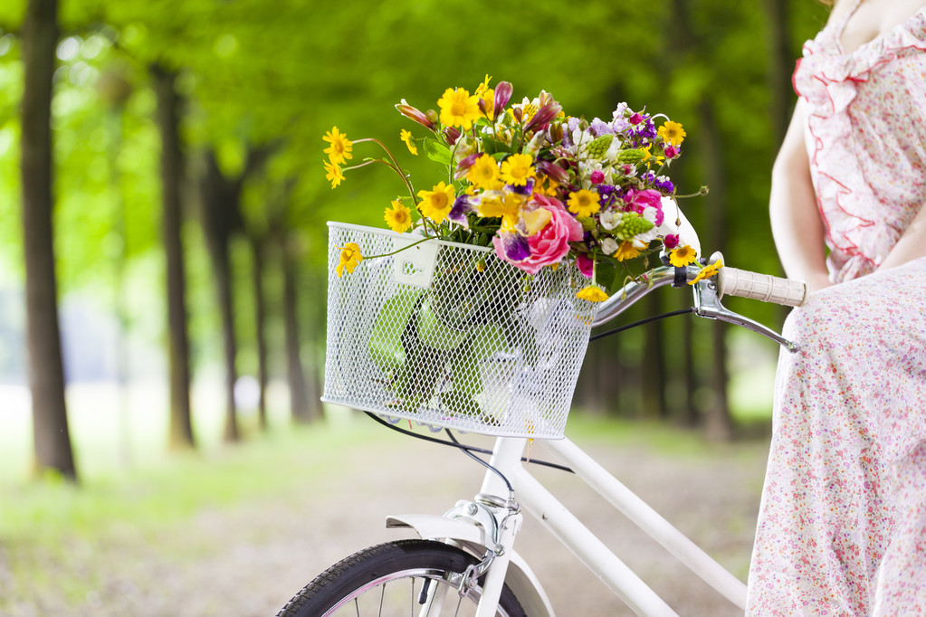 花とビンテージ自転車を保持している女性 - 写真・画像