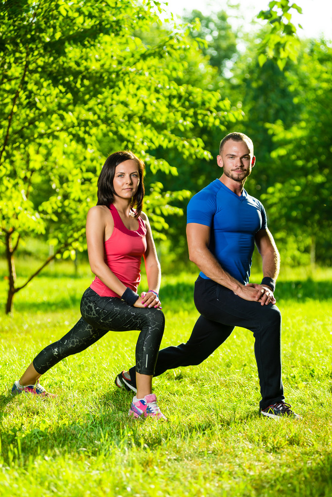 man en vrouw doen stretching oefeningen - Foto, afbeelding
