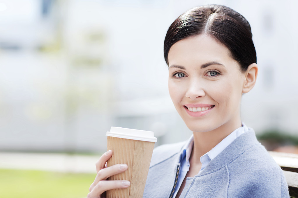 飲むコーヒーを屋外で女性の笑みを浮かべてください。 - 写真・画像