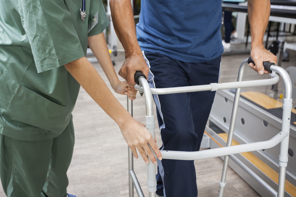 Міделю медсестра, допомагаючи старший людина, ступив за допомогою Уокер - Фото, зображення