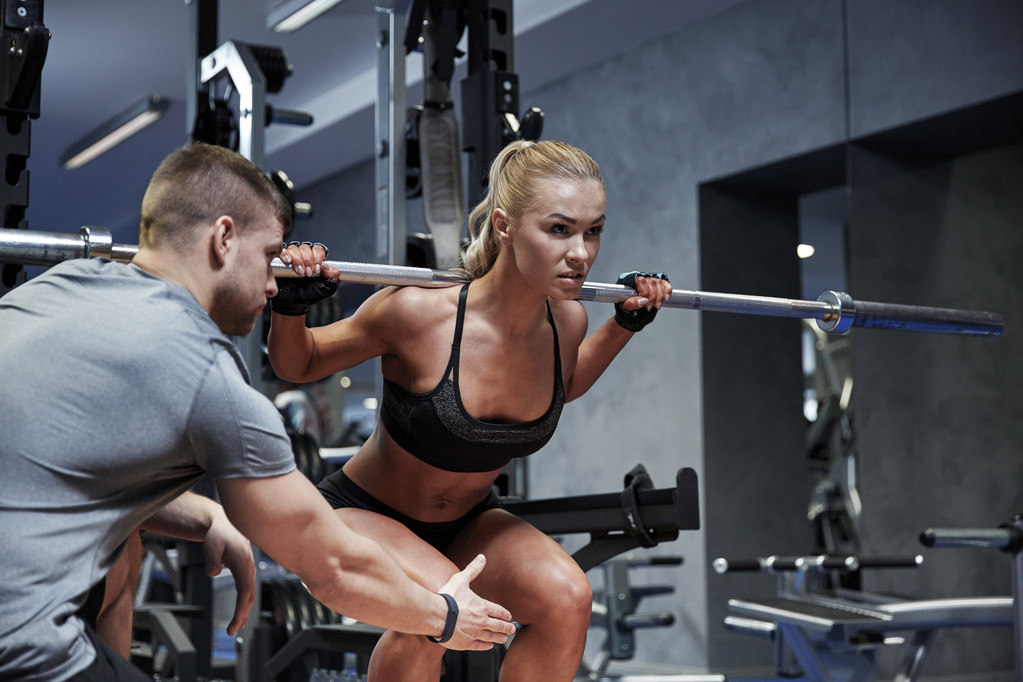 man and woman with bar flexing muscles in gym - Photo, Image