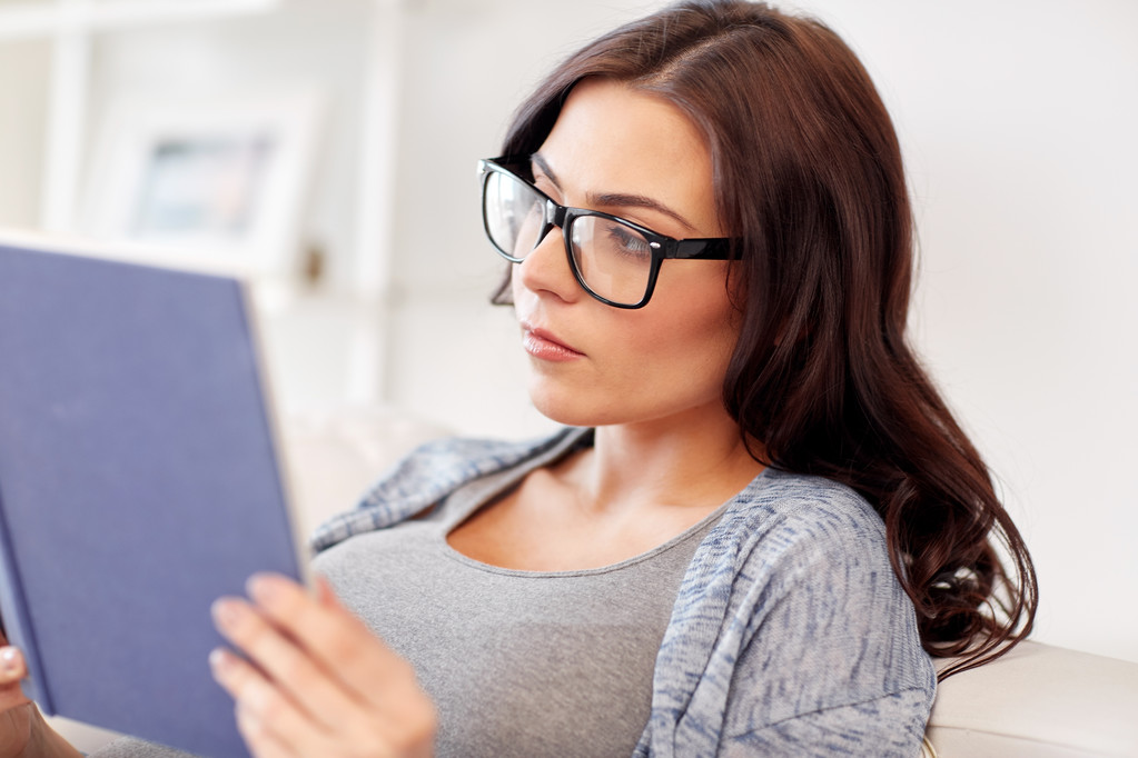 young woman in glasses reading book at home - Photo, Image