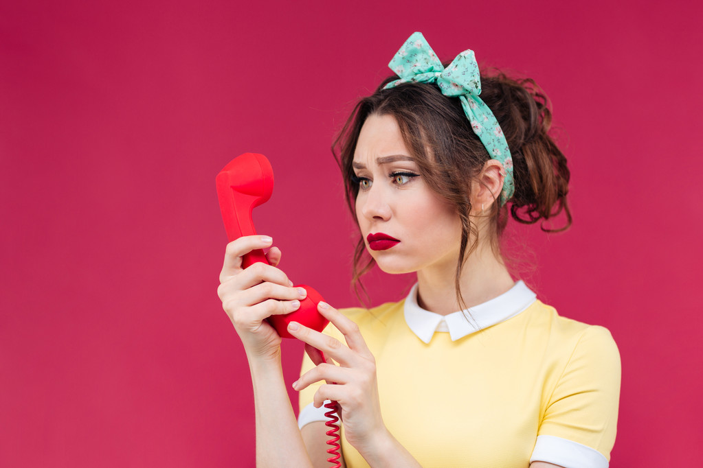 Üzgün güzel kadın kırmızı alıcı kullanarak ve telefonda konuşurken - Fotoğraf, Görsel