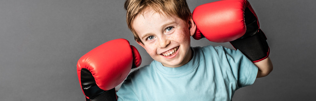 smiling young child with red hair with big boxing gloves - Photo, Image