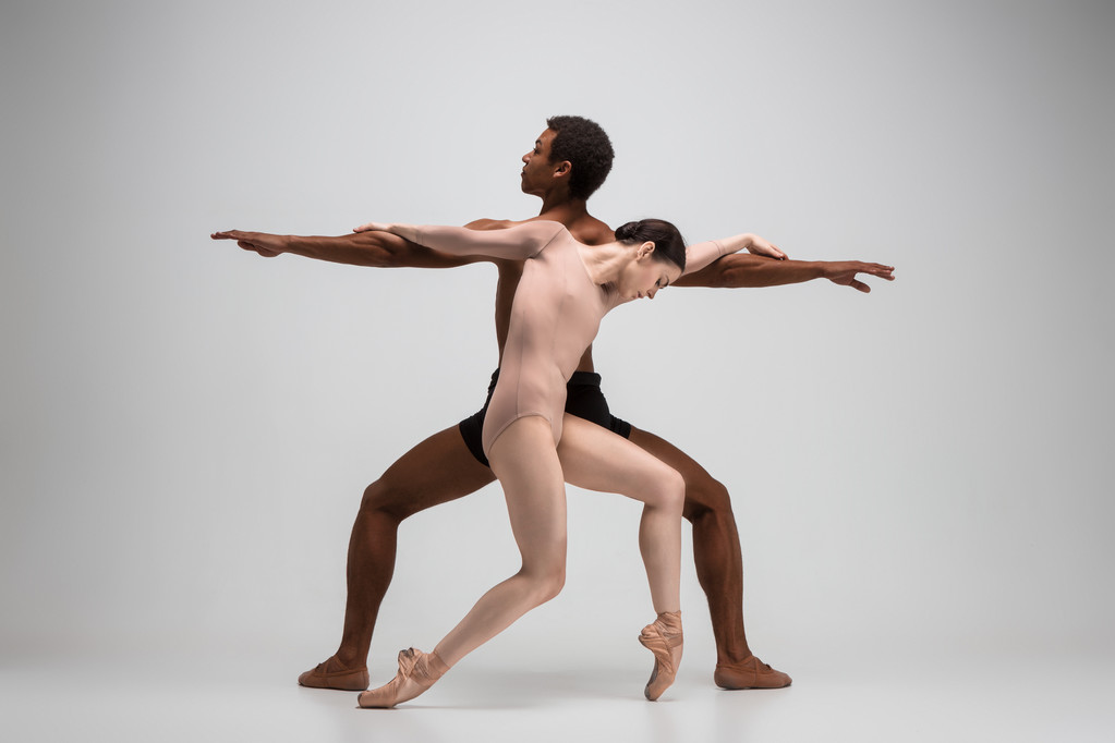 Paar balletdansers poseren over grijze achtergrond - Foto, afbeelding