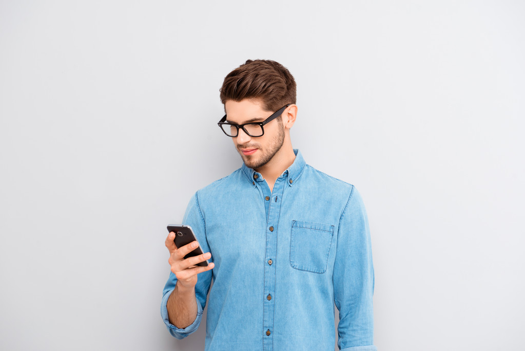 Портрет молодого хлопця в окулярах читання повідомлення по телефону
 - Фото, зображення