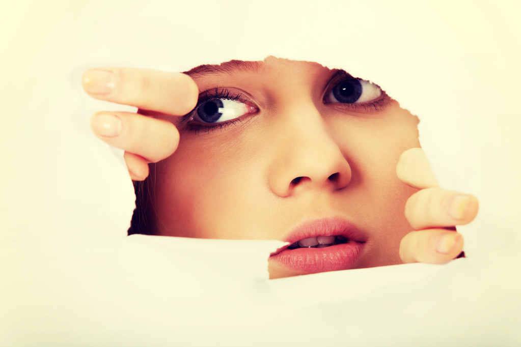 Tizenéves nő peeping lyuk a papír - Fotó, kép