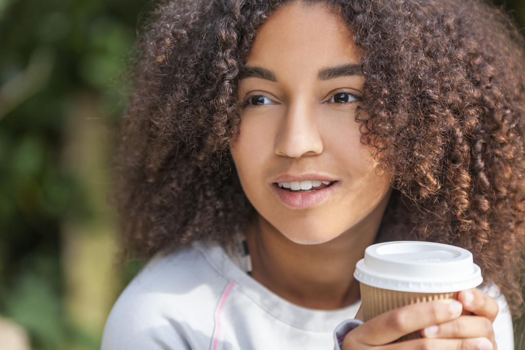 コーヒーを飲みながら混血アフリカ系アメリカ人の 10 代女性 - 写真・画像