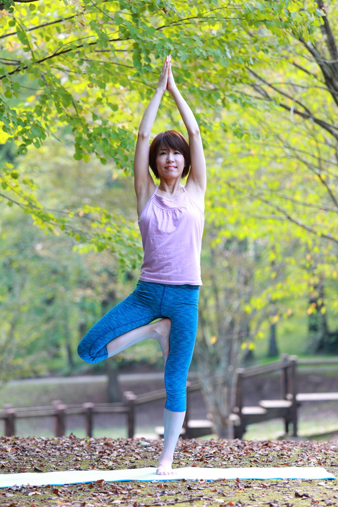 Japanese woman outside doing yoga tree pose - Photo, Image