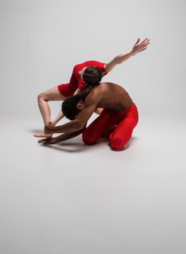 Paar balletdansers poseren over grijze achtergrond - Foto, afbeelding