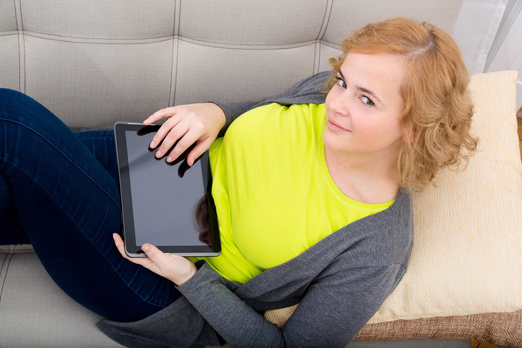 若い女性のタブレット Pc、ソファの上でリラックス   - 写真・画像