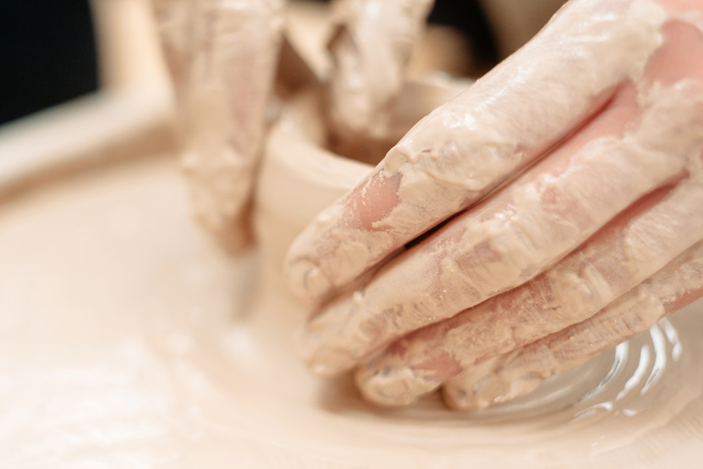 Гончары грязные руки на гончарных колесах крупным планом
 - Фото, изображение