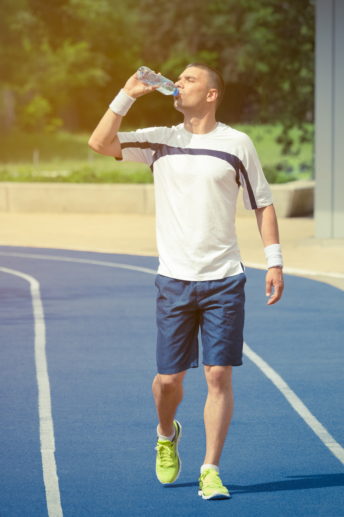 Koşucu koşu parkuru ve içme suyu şişeden yürüyüş - Fotoğraf, Görsel