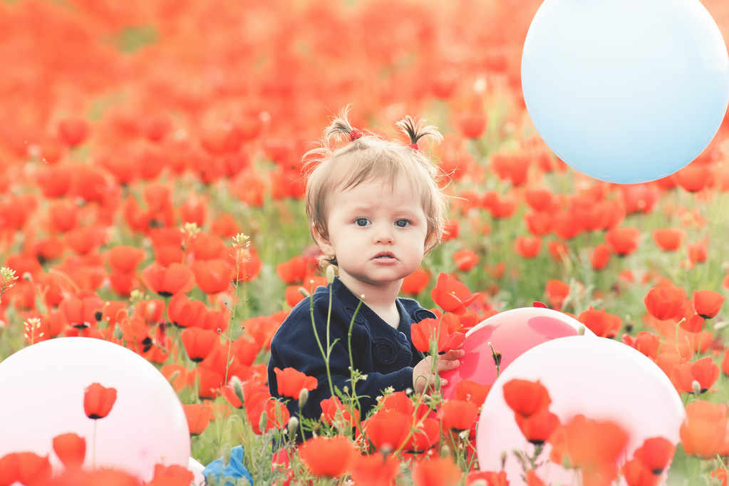Enfant drôle tenant un ballon en plein air au champ de pavot
 - Photo, image
