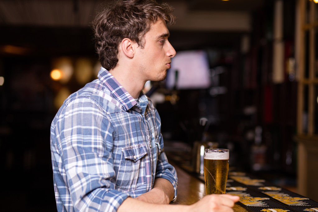одинокий мужчина, сидящий в баре и пьющий пиво
 - Фото, изображение