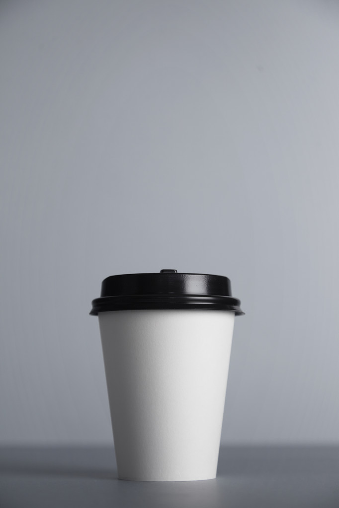 біла паперова чашка з чорною шапочкою, представлена спереду
 - Фото, зображення