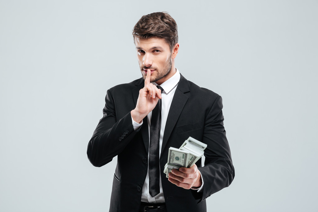 Pohledný mladý podnikatel drží peníze a mlčení známek - Fotografie, Obrázek