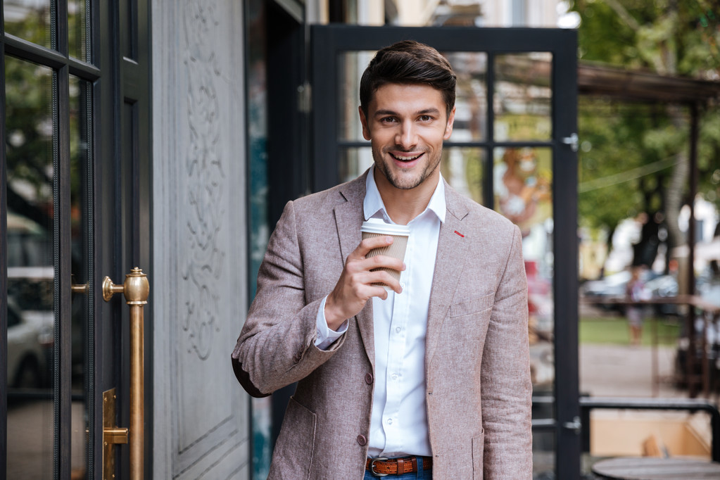 Jonge zakenman buiten een kopje koffie drinken - Foto, afbeelding
