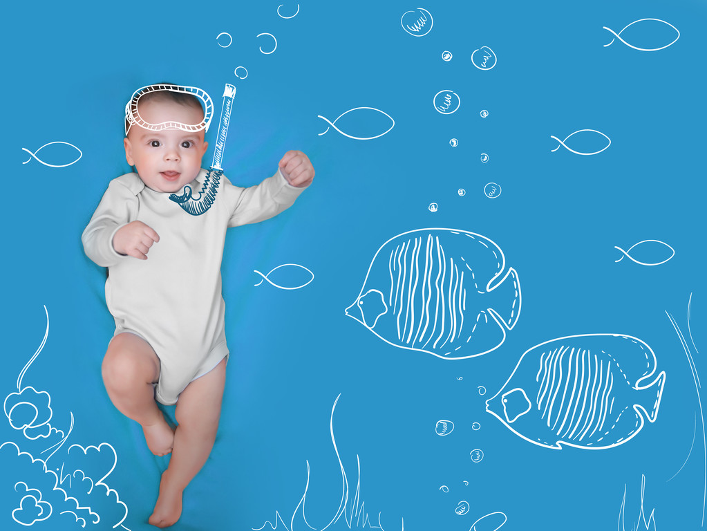 Bebê encantador com máscara pintada e peixes em um fundo azul
 - Foto, Imagem