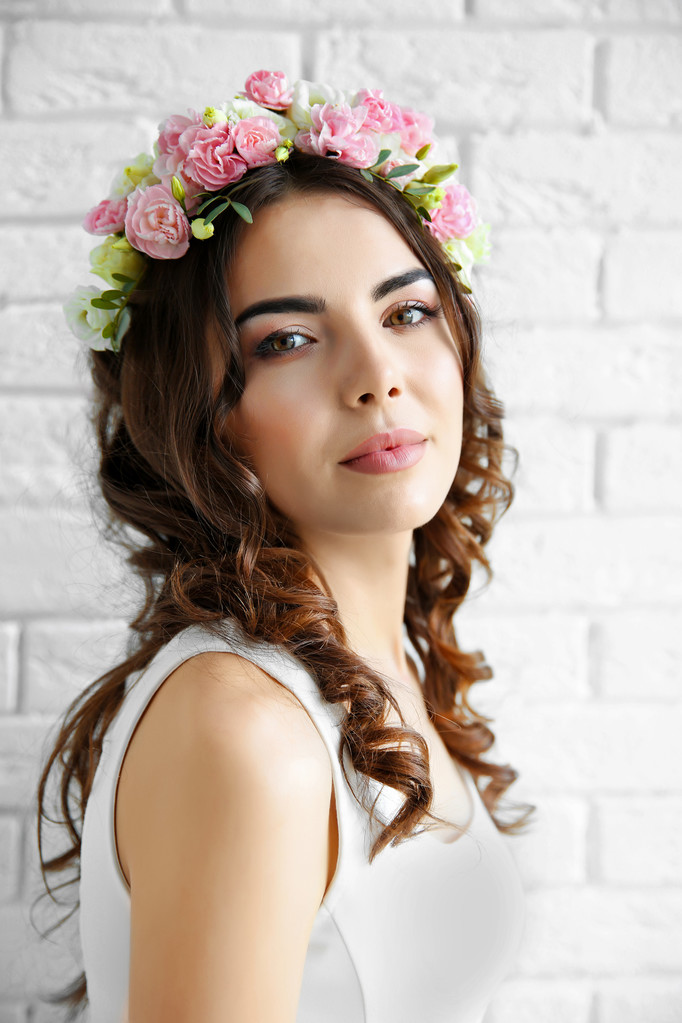 Kaunis nuori nainen kukkia pään päällä
 - Valokuva, kuva