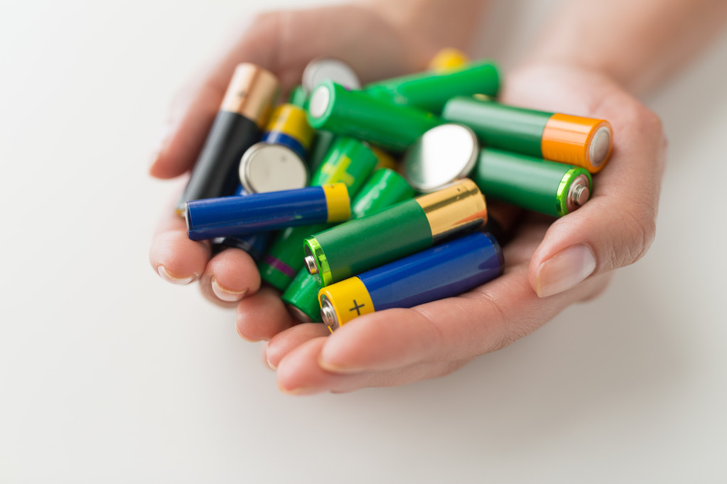 Nahaufnahme von Händen, die Alkaline-Batterien halten - Foto, Bild