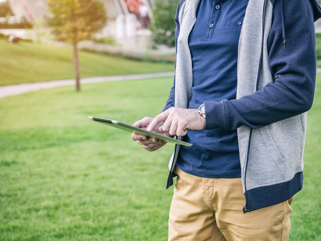 Jeune homme en veste écran tactile de tablette numérique dans le parc
 - Photo, image