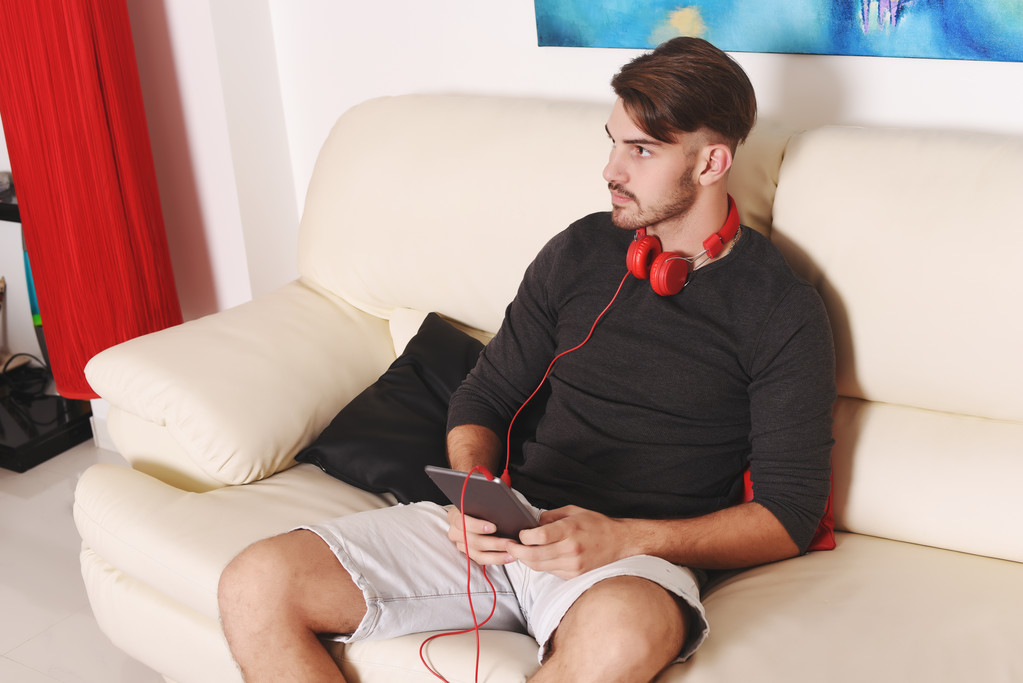 Młody człowiek słuchanie muzyki z tabletem  - Zdjęcie, obraz